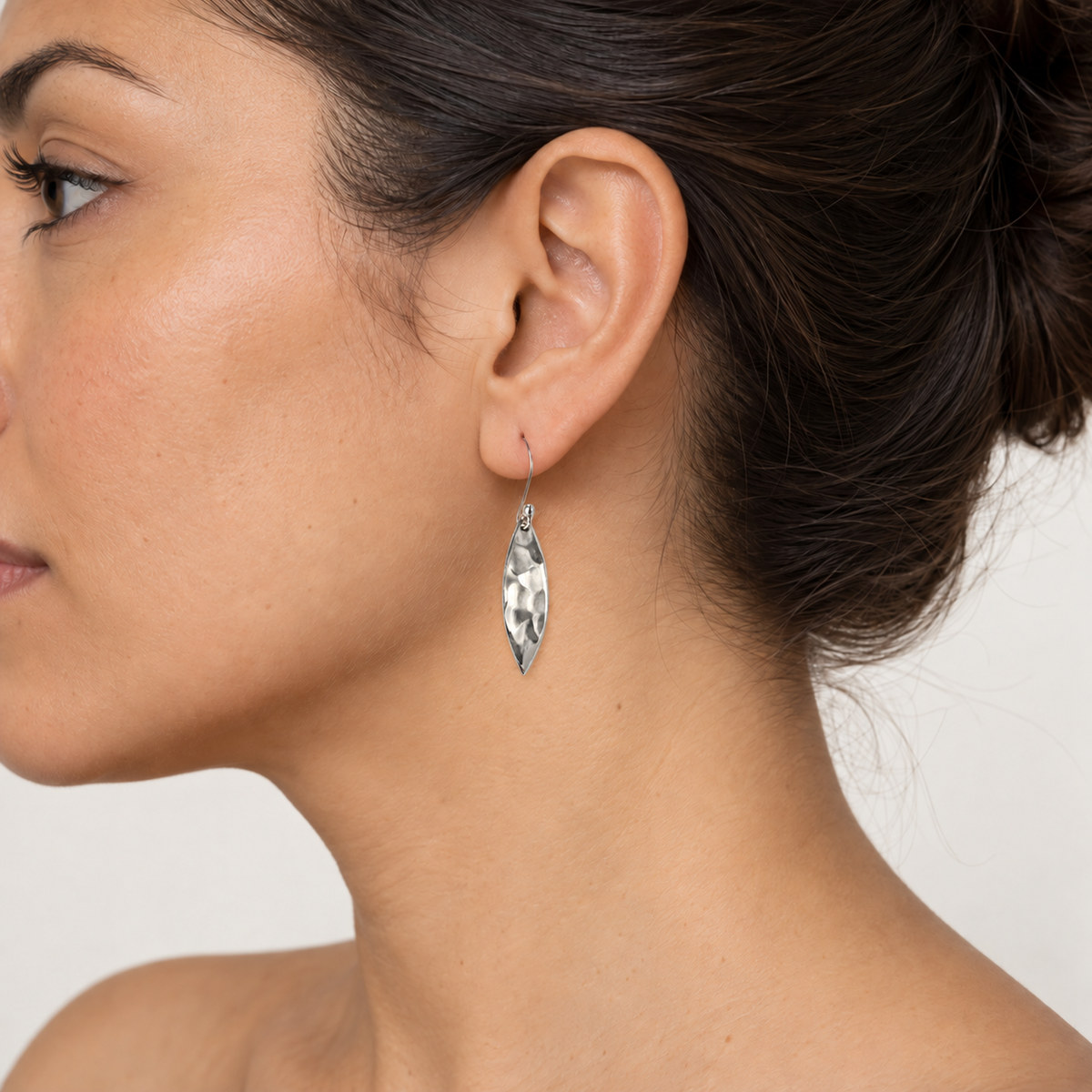 Vista de los aretes martillados en una modelo del set de publicación